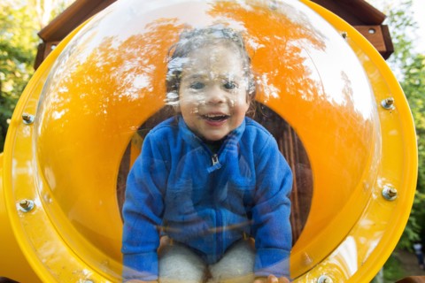 Caucasian baby girl smiling in playground bubble