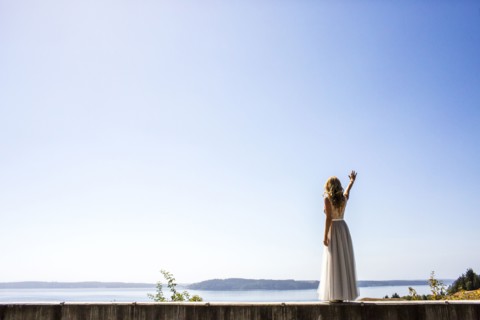 Caucasian bride waving near river