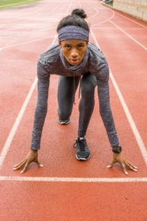 Black woman waiting at starting line on track