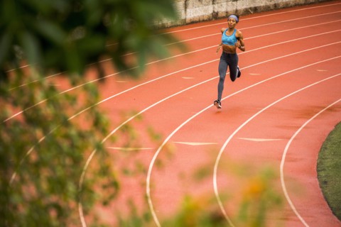 Black woman running on track