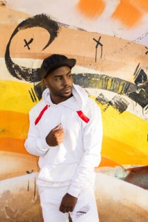 Serious Black man leaning on graffiti wall