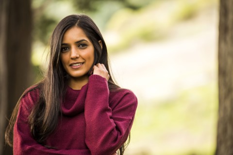 Portrait of smiling Indian woman wearing sweater