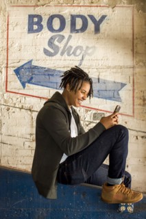 Androgynous Mixed Race woman texting on cell phone