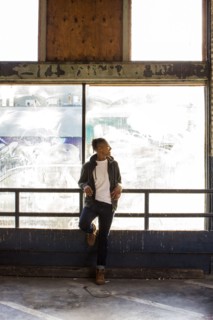 Smiling androgynous Mixed Race woman leaning on railing near window
