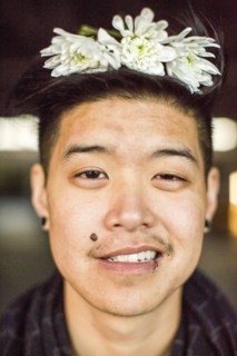 Portrait of androgynous Asian man with flowers in hair