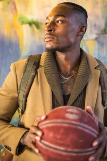 Black man wearing backpack holding basketball