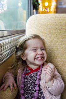 Caucasian girl grinning near window on train