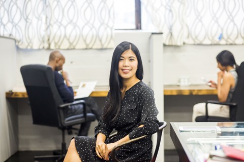Portrait of smiling Asian woman sitting in office