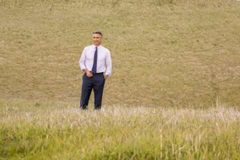 Smiling Caucasian businessman standing in grass