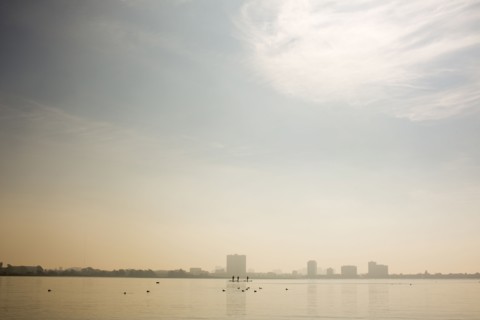 Distant people paddleboarding in river