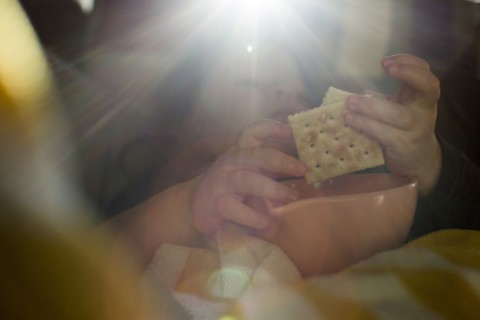 Hands of Caucasian girl eating crackers