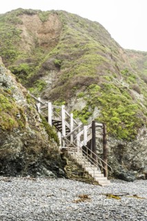 Staircase to hill on rocky beach