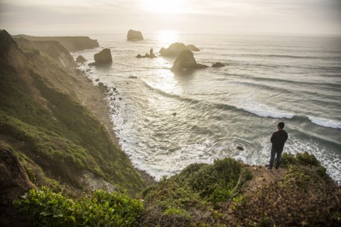 Caucasian man admiring scenic view of ocean sunset