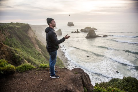 Caucasian man admiring scenic view of ocean sunset