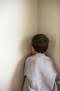 Mixed Race boy standing in corner