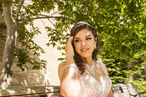 Smiling Hispanic girl under a tree