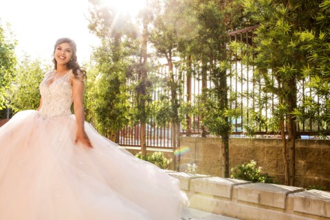 Smiling Hispanic girls wearing gown in park