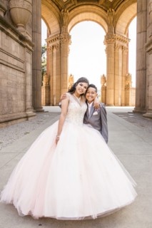 Hispanic girl wearing gown hugging boy