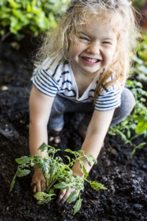 Caucasian girl posing with plant in garden
