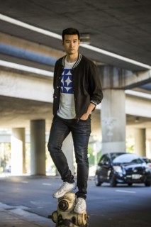 Serious Chinese man standing on hydrant