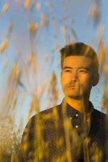 Serious Chinese man standing in wheat
