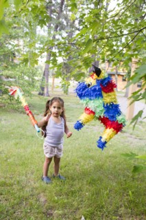 Mixed race girl hitting pinata outdoors