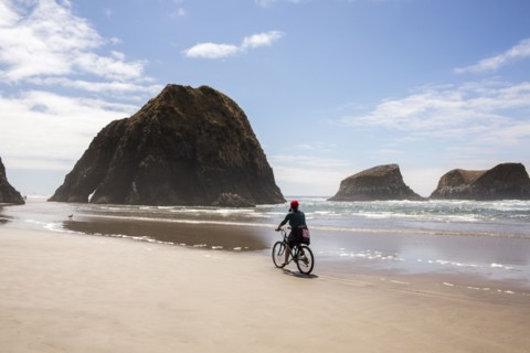 Caucasian woman riding bicycle on beach