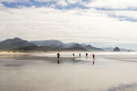 Distant people running on beach