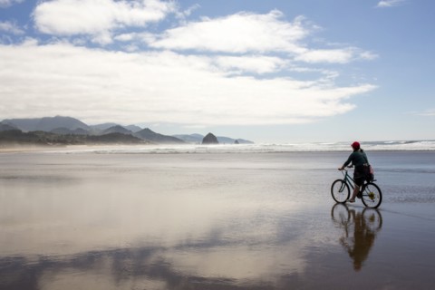 Caucasian woman riding bicycle on beach