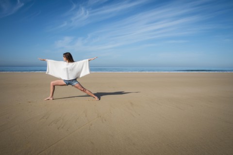 Caucasian woman practicing yoga on beach