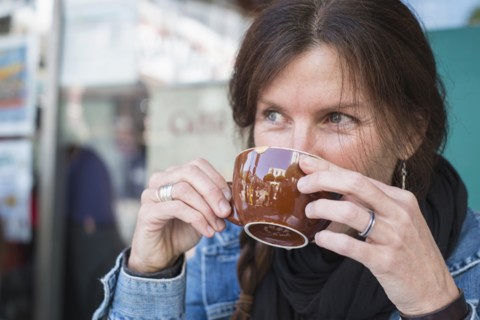 Caucasian woman drinking cup of coffee outdoors