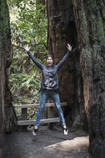 Caucasian woman jumping for joy in forest