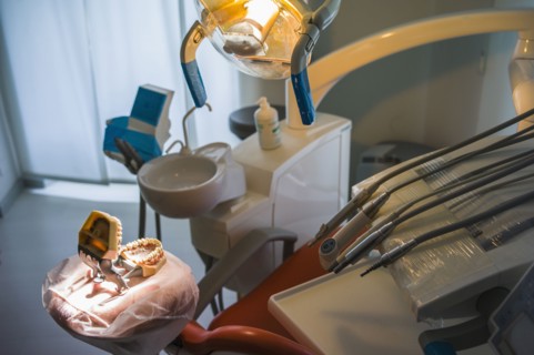 Empty chair and dentures in office of dentist