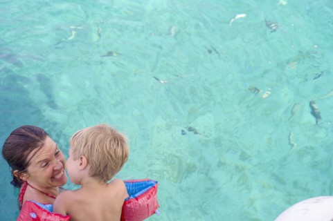 Caucasian mother teaching son to swim in pool