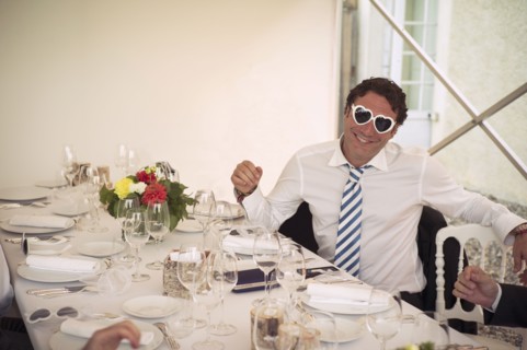 Caucasian man wearing heart-shaped glasses at table