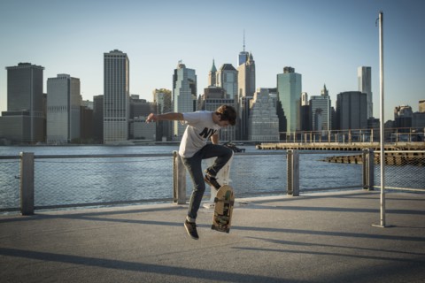Caucasian skateboarder doing trick at waterfront
