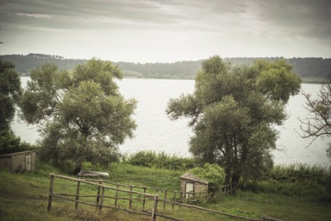 Fences around rural fields near still lake
