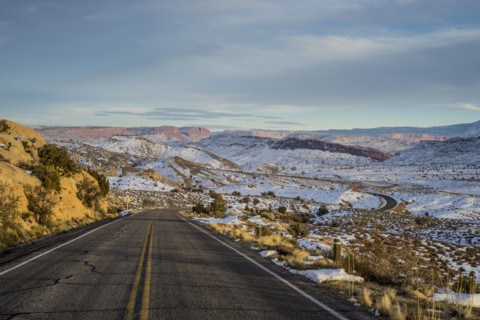 Empty road through snowy remote landscape