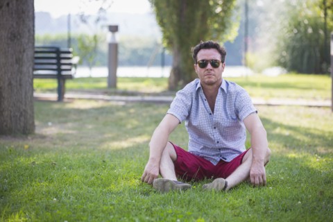 Caucasian man sitting in grass in park