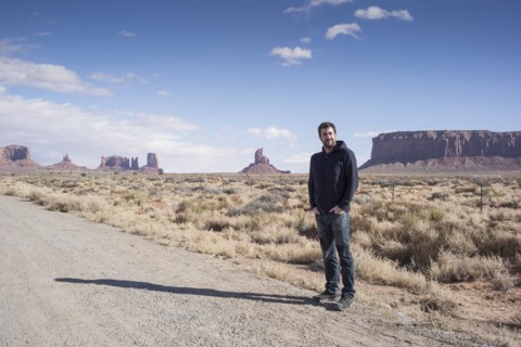 Caucasian man standing on desert dirt road