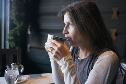 Caucasian woman drinking coffee in cafe