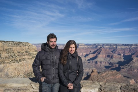 Caucasian couple standing over Grand Canyon