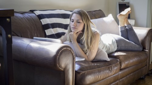 Caucasian woman using laptop on sofa