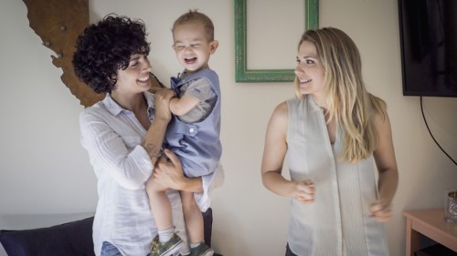 Caucasian lesbian mothers and baby son in living room