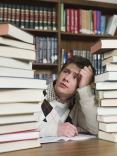 Student staring at stacks of books in library