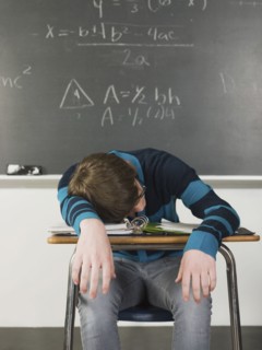 Student sleeping at desk in classroom