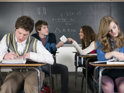 Students passing love note in classroom