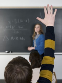 Student raising hand in classroom