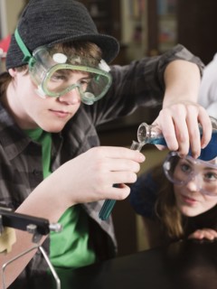 Students performing experiment in science lab classroom