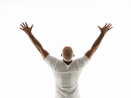 Rear view of older man cheering with arms raised